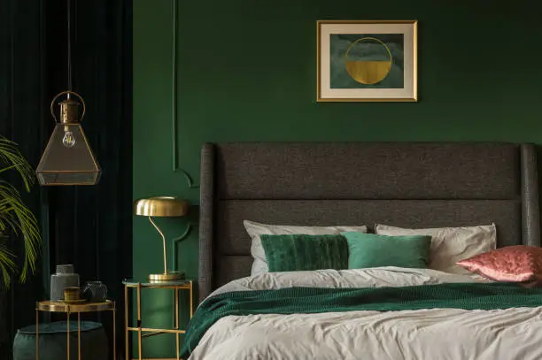 Bedroom with deep green walls, dark trim, and clean finishes by an interior painter in Orchid, FL.