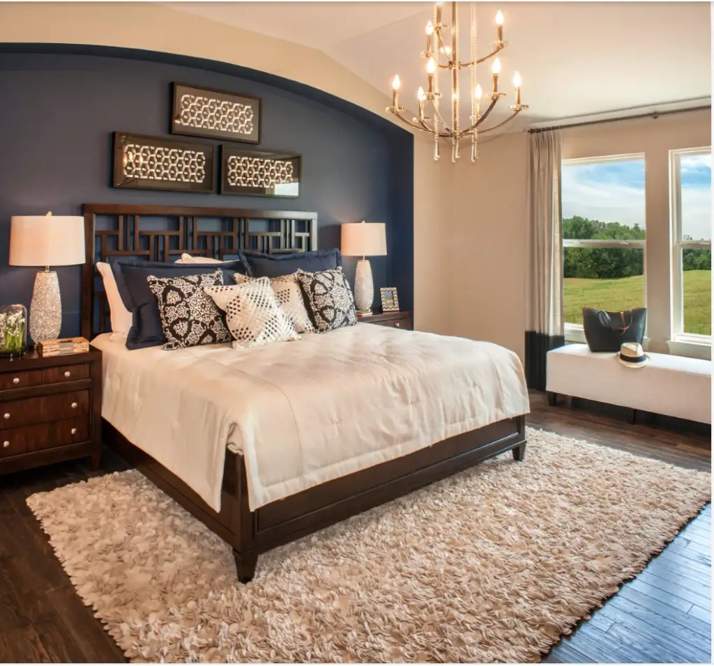 Bedroom with a navy blue accent wall and warm neutral walls by an interior painter in Orchid, FL.